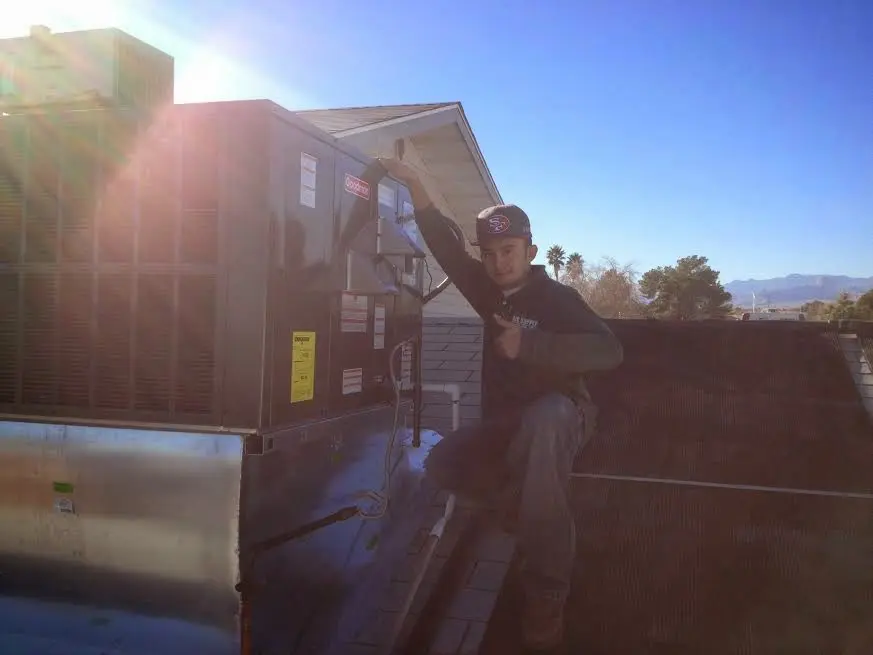 HVAC technician performing AC Tune-Up on a rooftop unit in Winona